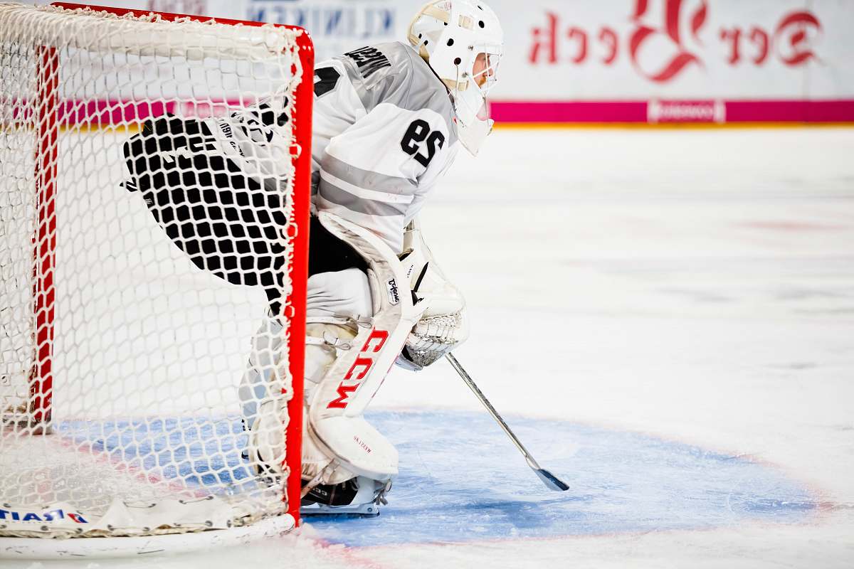person person guarding goalie net in field helmet