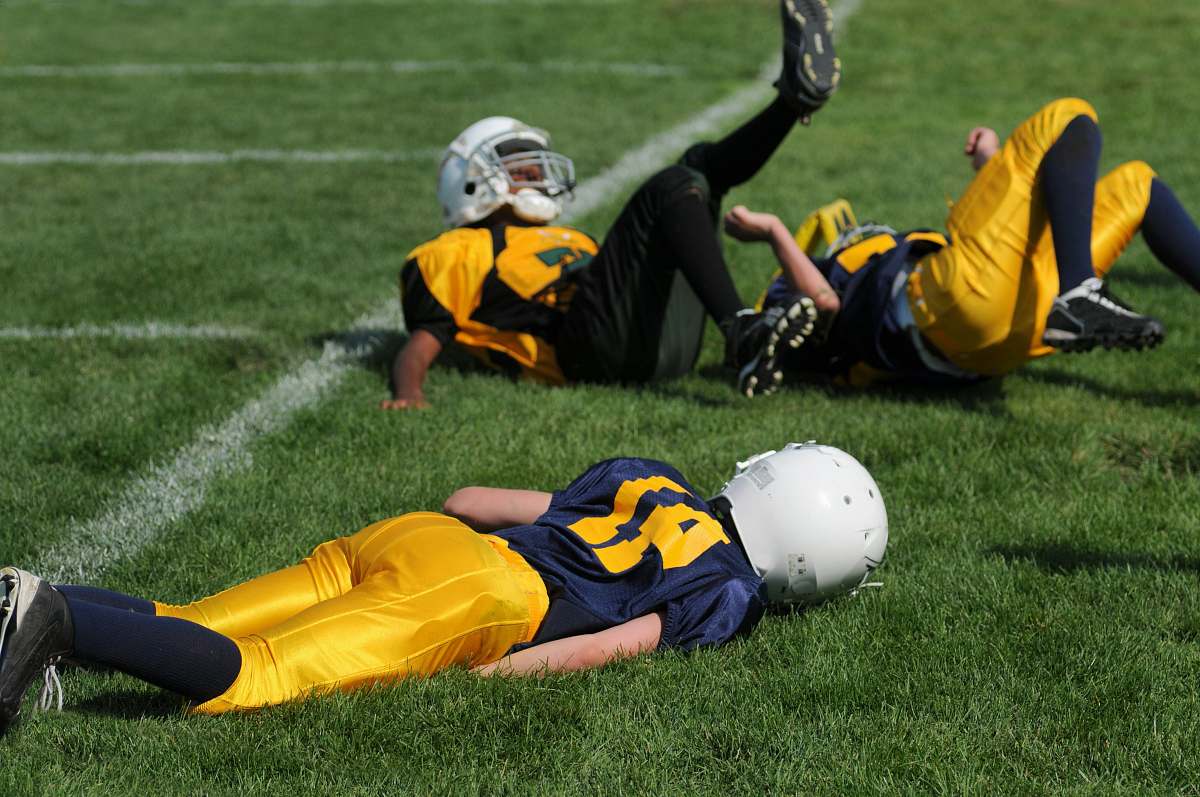 football player lying on field helmet