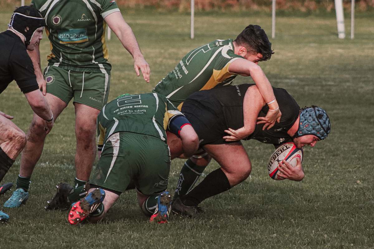 human rugby players tackling each other while on field person