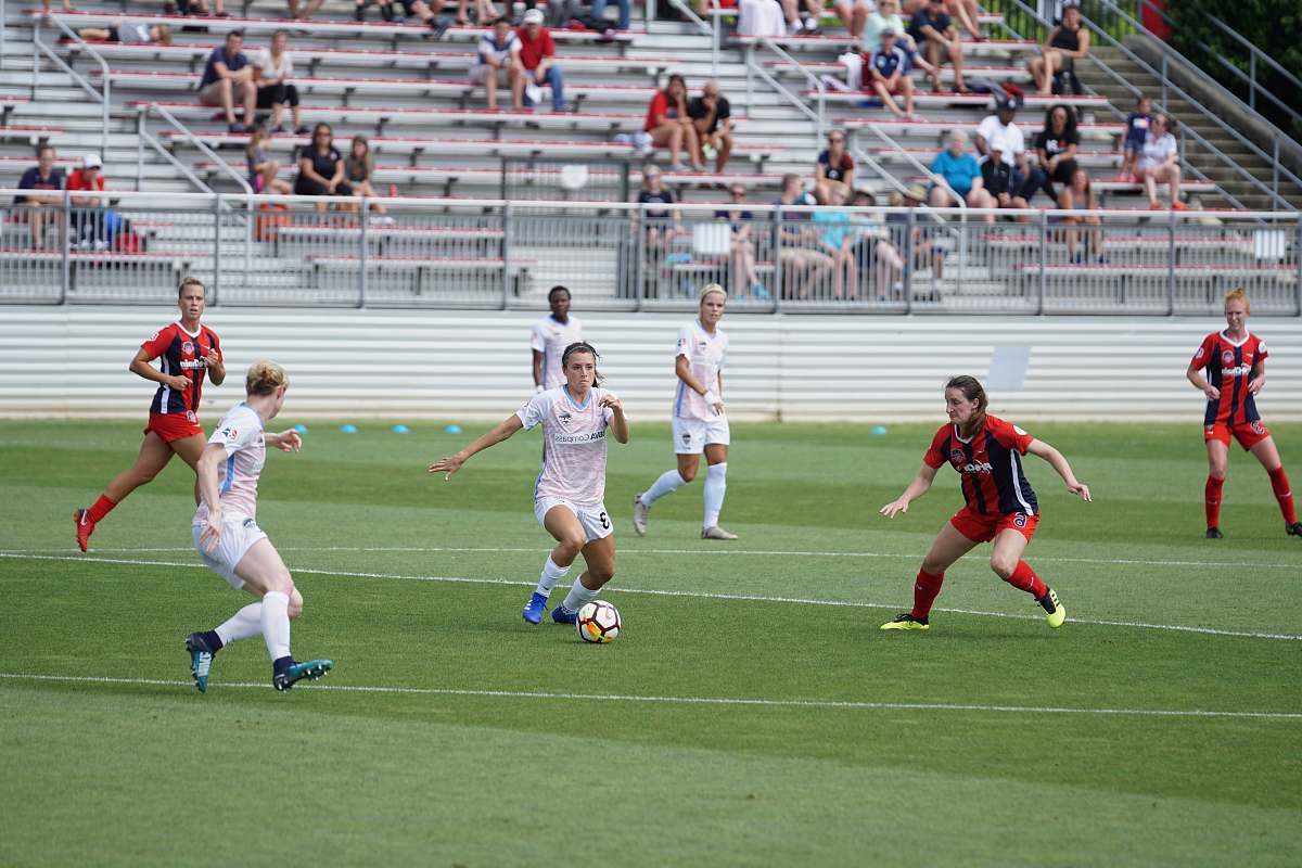 Experience the thrill of a daytime soccer match where two dynamic teams engage in an intense competition on the field. The bright sunlight casts vibrant shadows as players showcase their skills, teamwork, and determination. This energetic scene captures the essence of sportsmanship and can be utilized for promotional materials, sports articles, websites, and social media posts aimed at sports enthusiasts and local events.