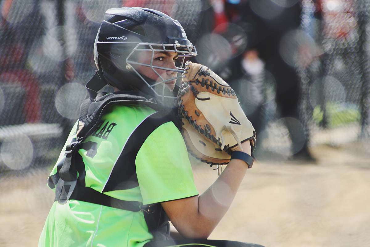 softball woman wearing brown Easton baseball mitt playing baseball baseball