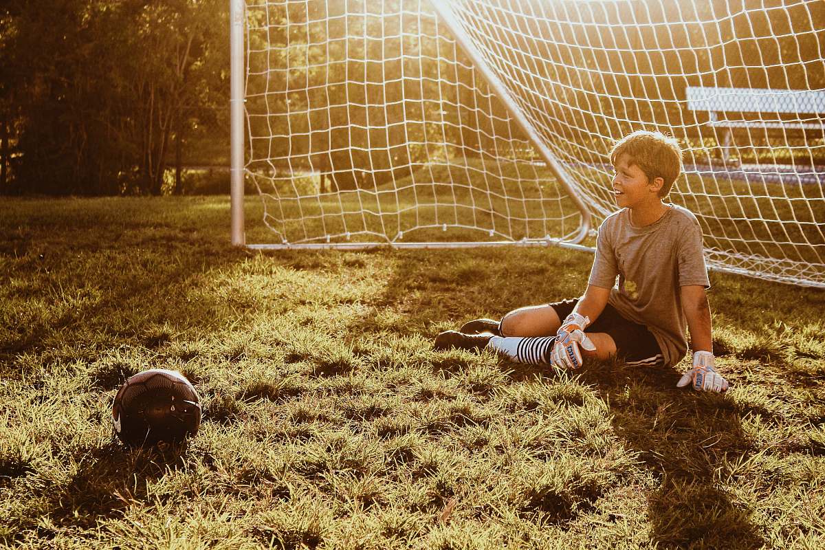 Soccer Goal Keeper Sitting On Grass Field Person Image Free Photo