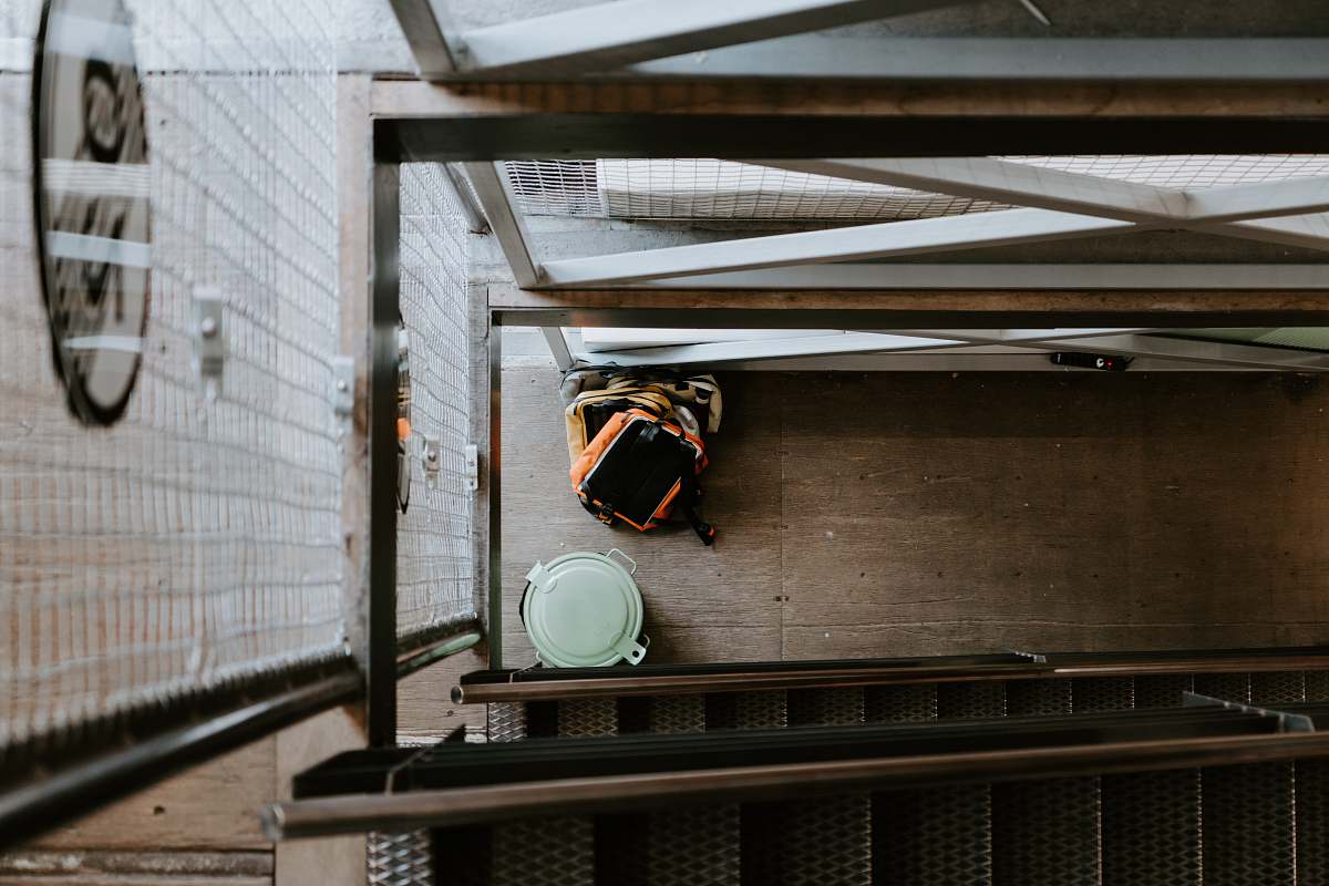 apparel orange backpack beside trash bin clothing