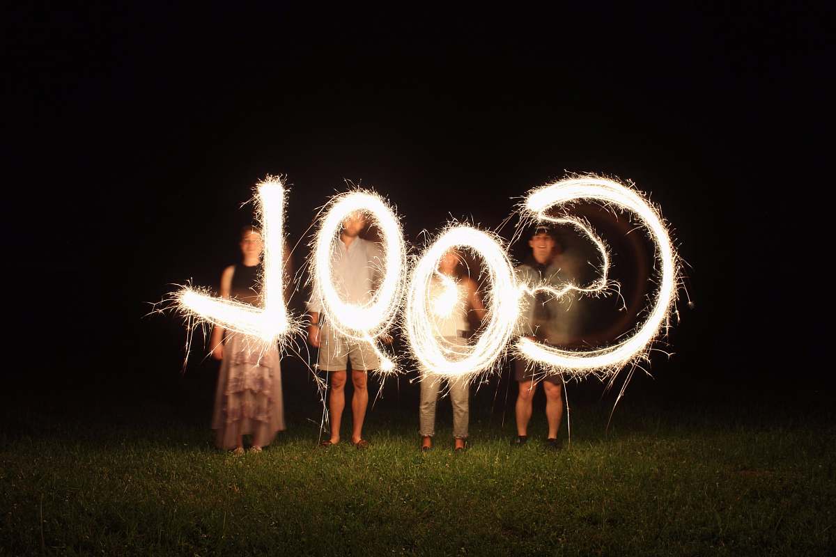 cool four people holding fireworks and forming cool word light