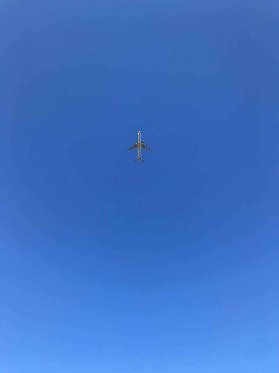 flying gray airplane flying during daytime blue