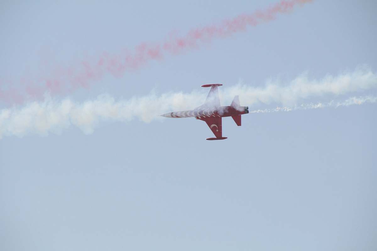flying red airplane under blue sky during daytime bird