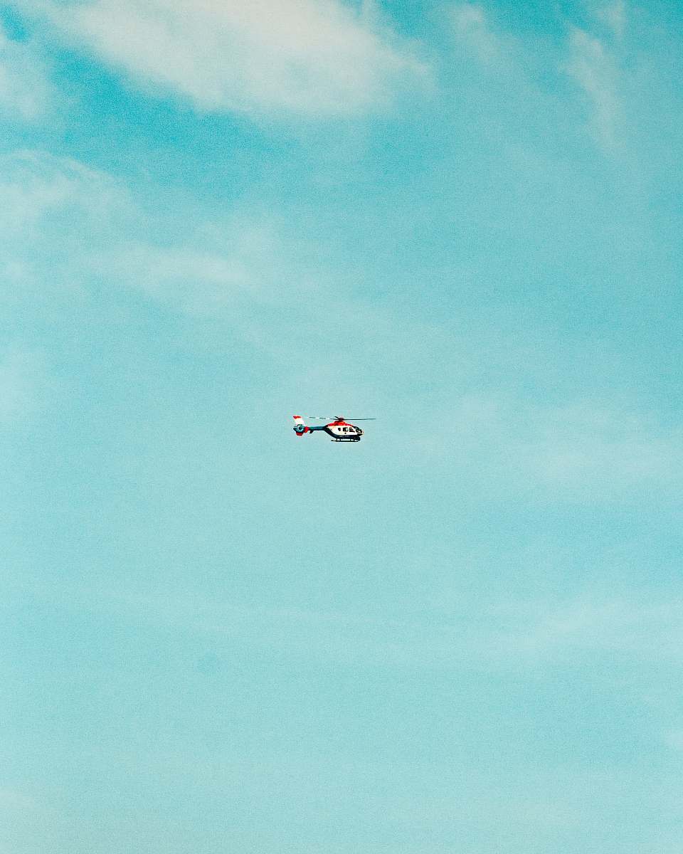 flying red and white helicopter bird