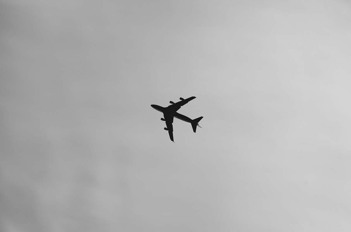 black-and-white selective focus photography of airplane on air during daytime flying