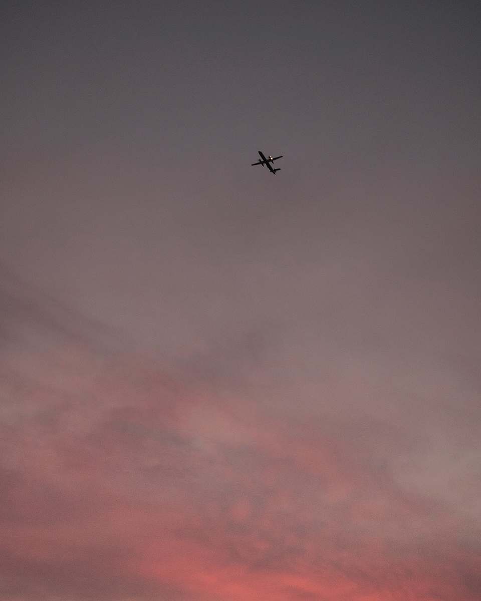 grey airplane on mid air under cloudy sky flying