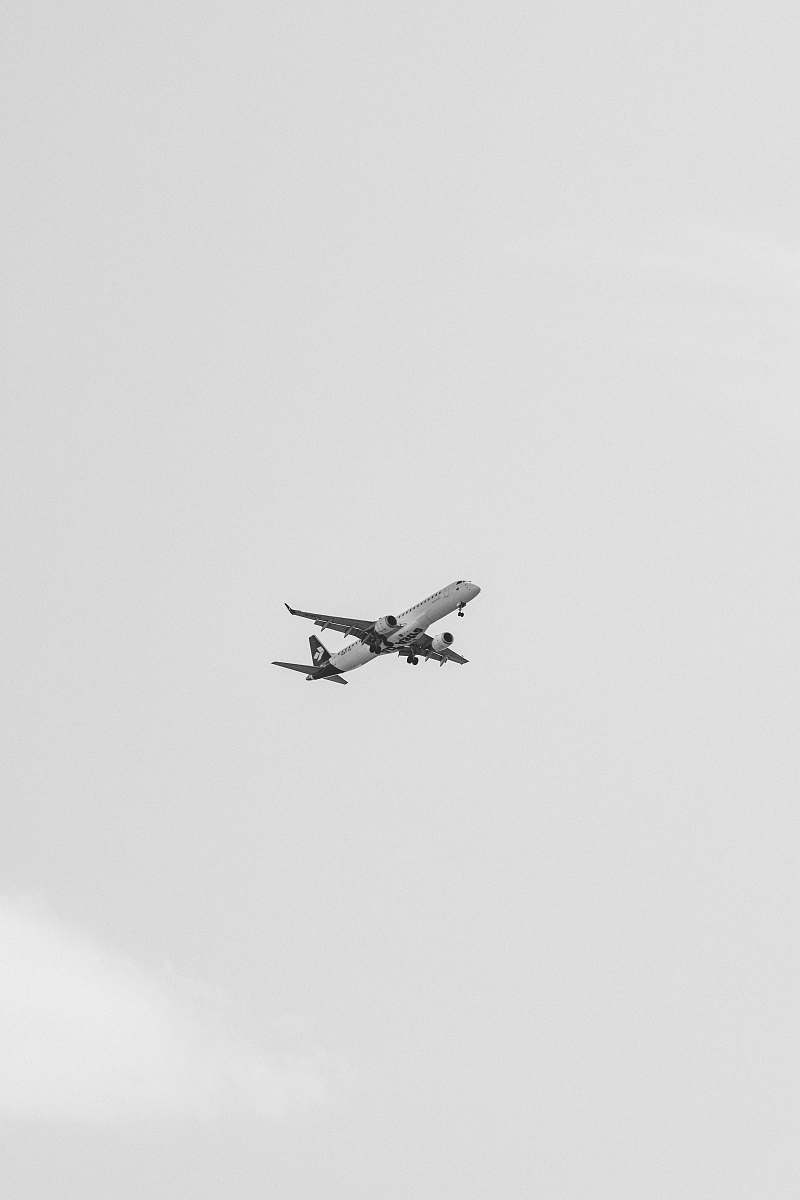 black-and-white time-lapse photography of an airplane in flight grey