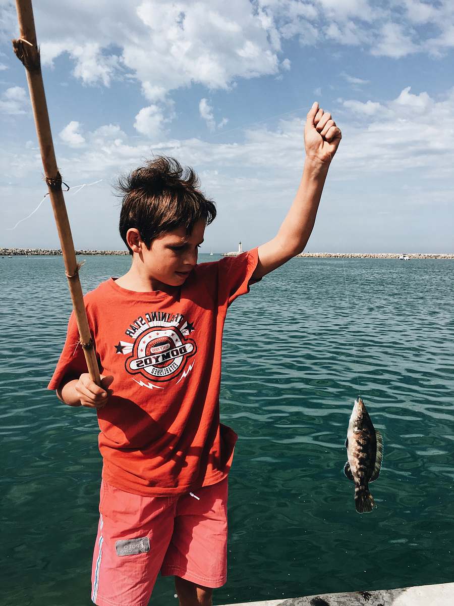 fish boy holds fish perch