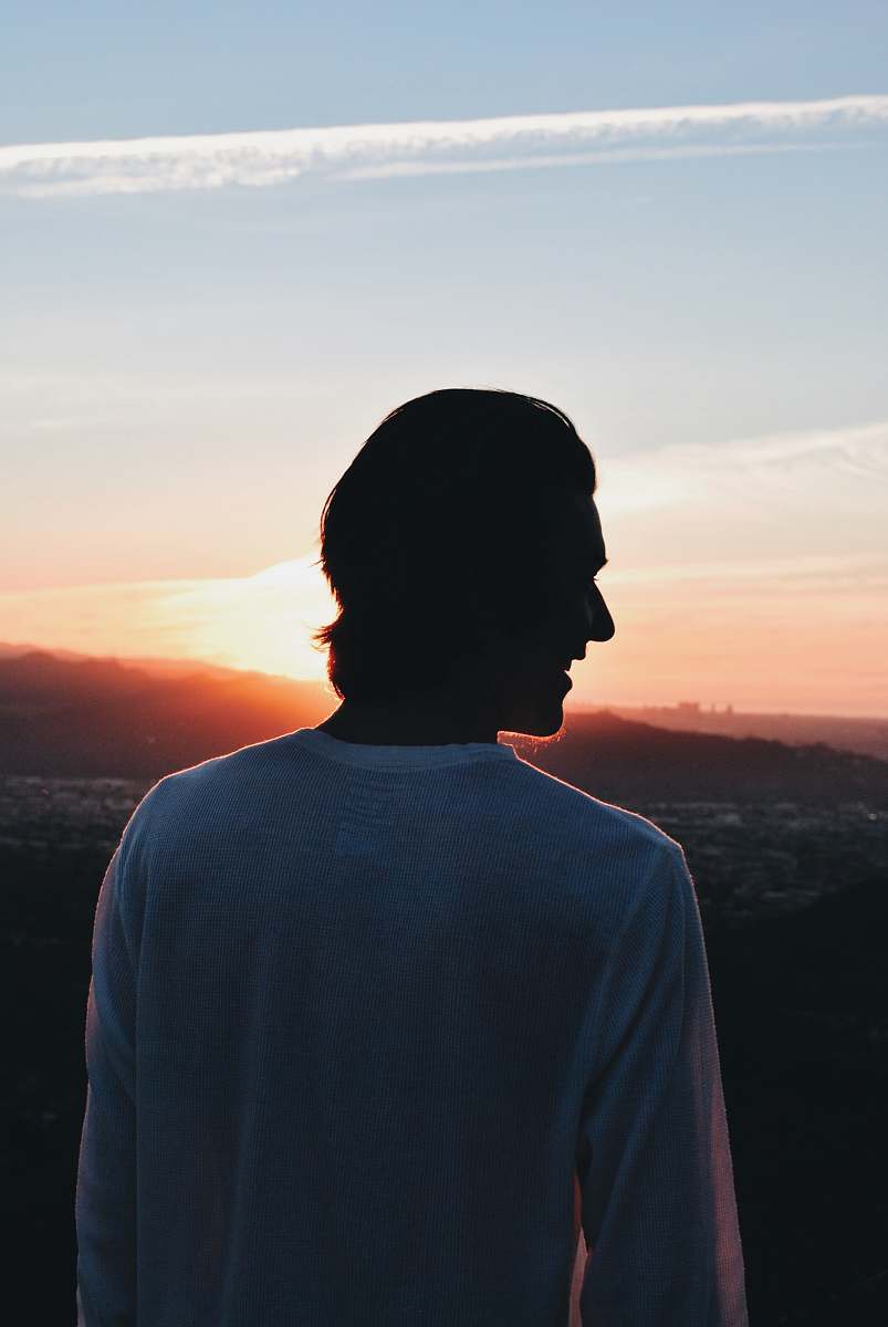 clothing smiling man wearing white crew-neck long sleeved shirt looking left side sleeve