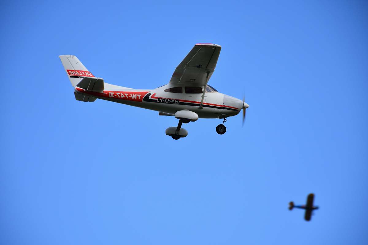 animal white and red biplane under blue sky flying