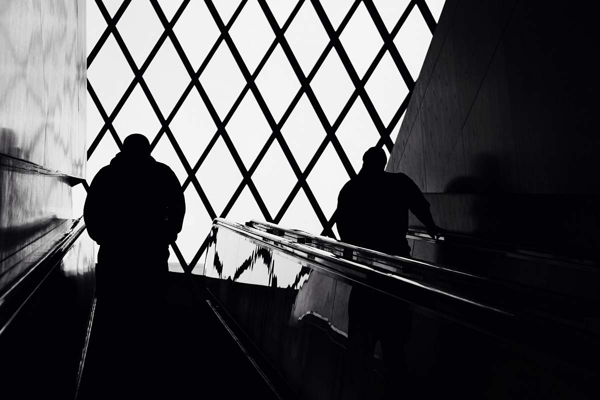 banister man standing on escalator handrail