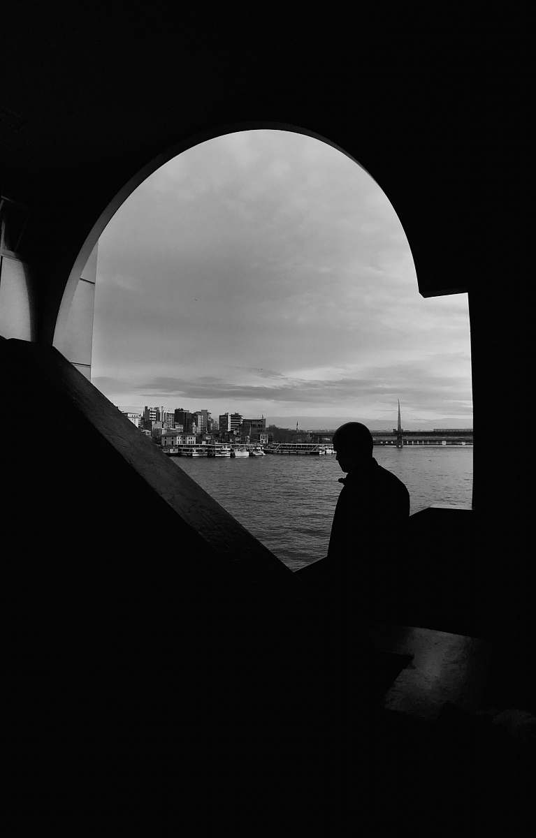 building silhouette of man near body of water architecture