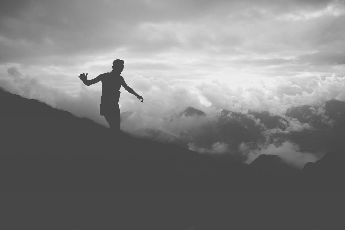 person silhouette of man on mountain hill grey