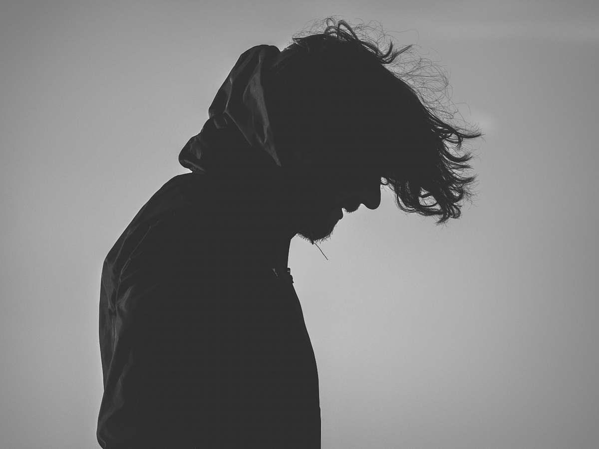 silhouette silhouette of man wearing hoodie looking down grey