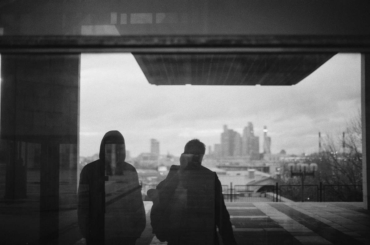 human silhouette of two people on glass grey