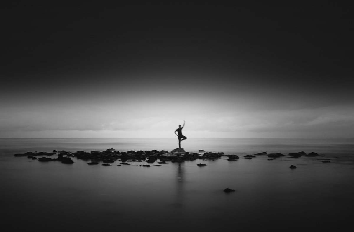 grey silhouette photo of person at middle of sea silhouette