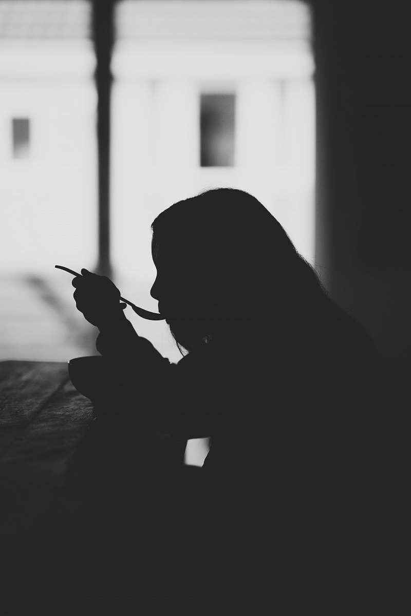 silhouette woman eating at table grey