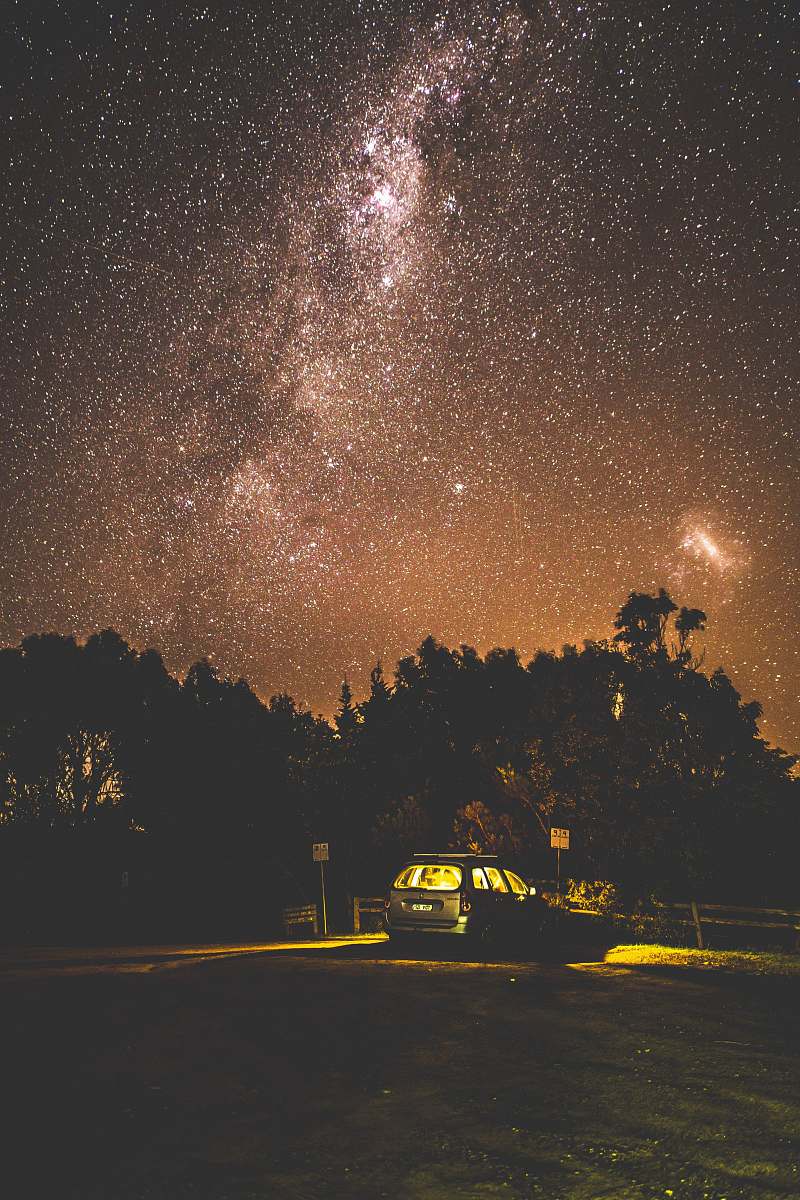 vehicle milky way over silhouette trees and car stars