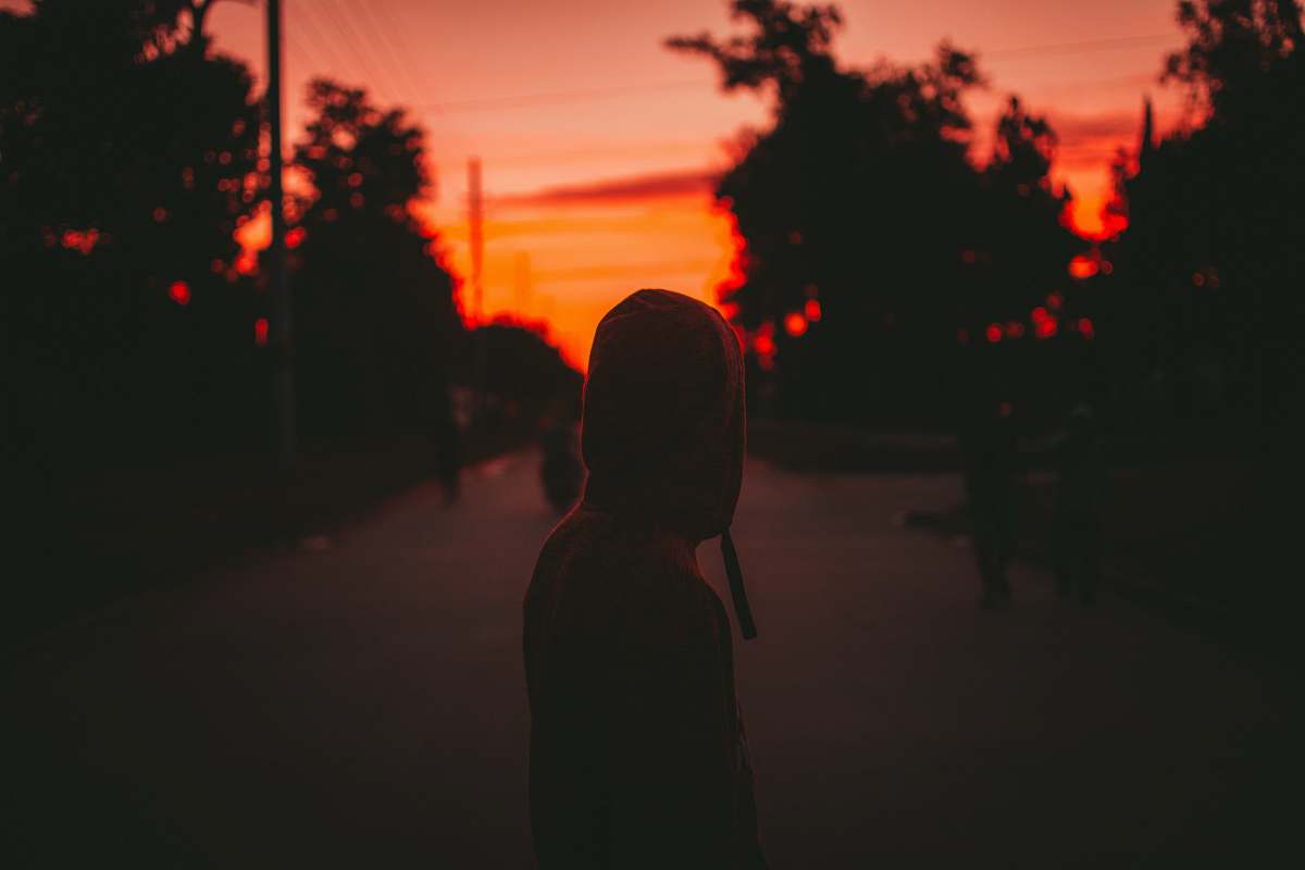 light person wearing hoodie standing on road nature