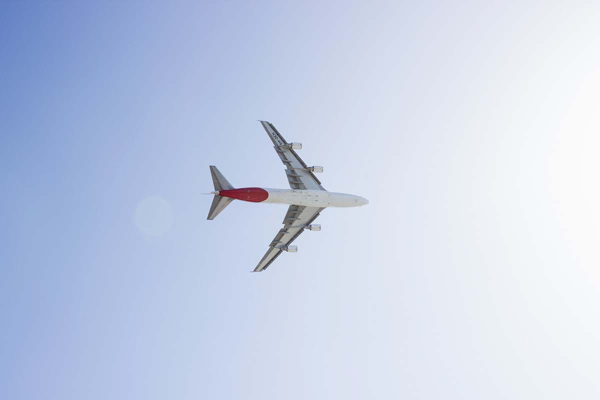 airplane white and red plane in sky during daytime aircraft