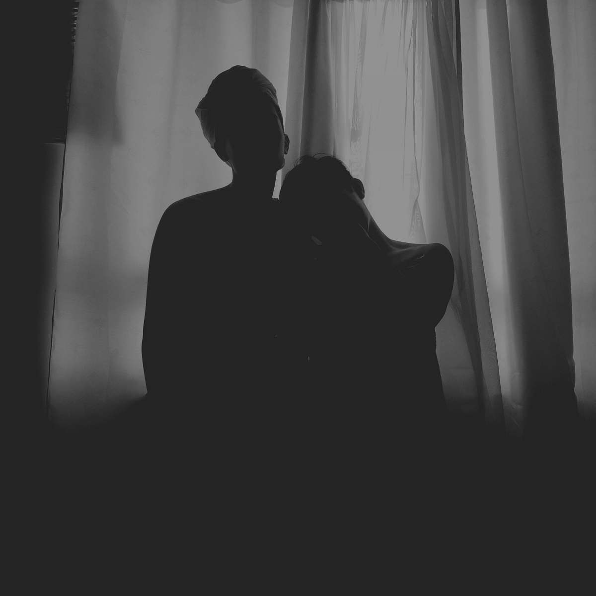 silhouette two human standing at the front of white curtain black-and-white
