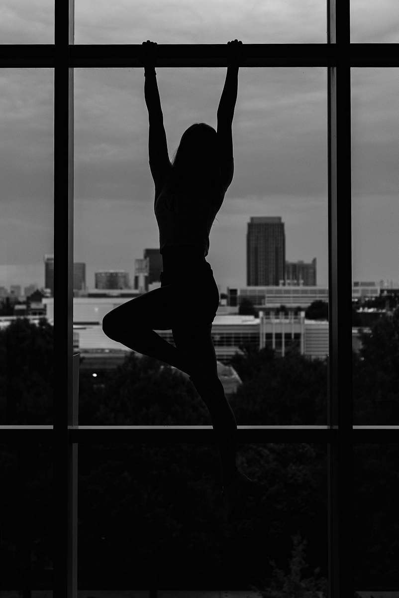 person girl hanging on steel beam black-and-white