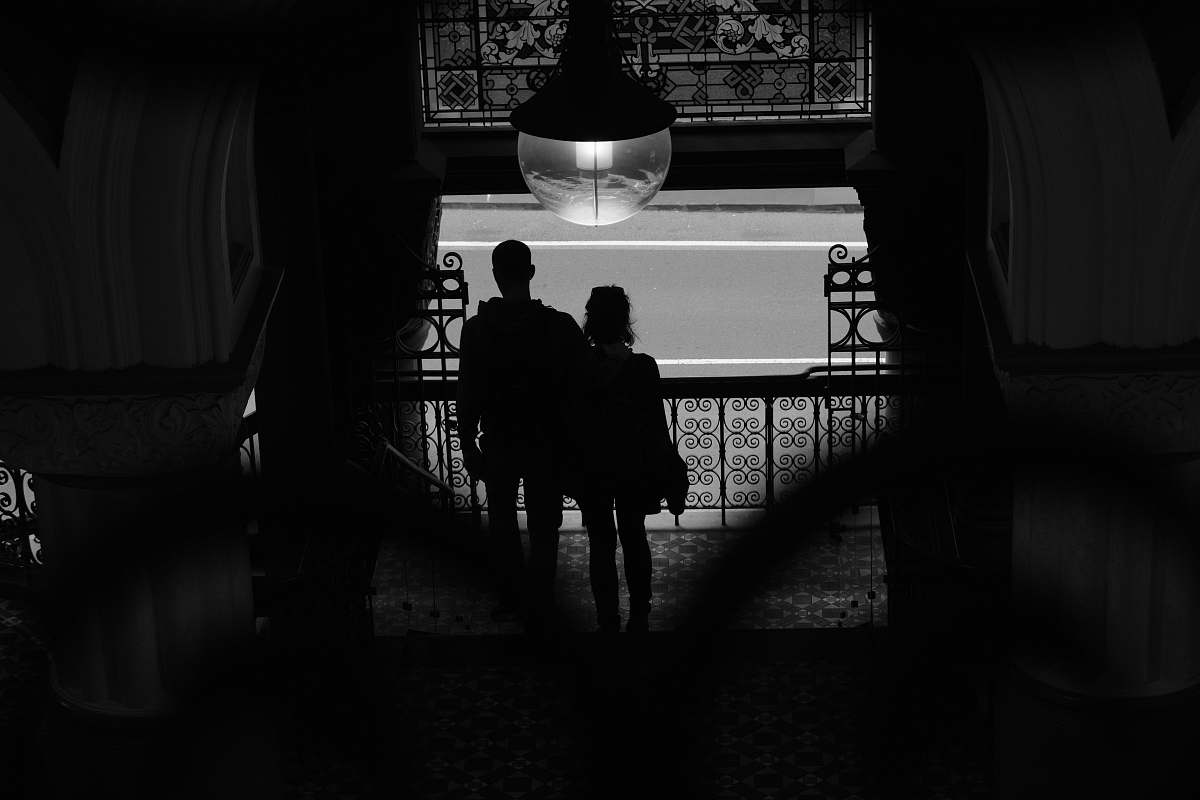 person light bulb across silhouette of man and woman black-and-white
