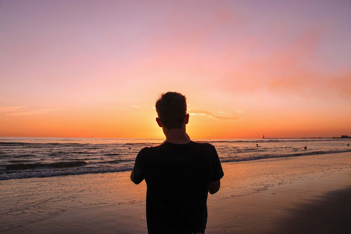 person man facing sea during golden hour nature