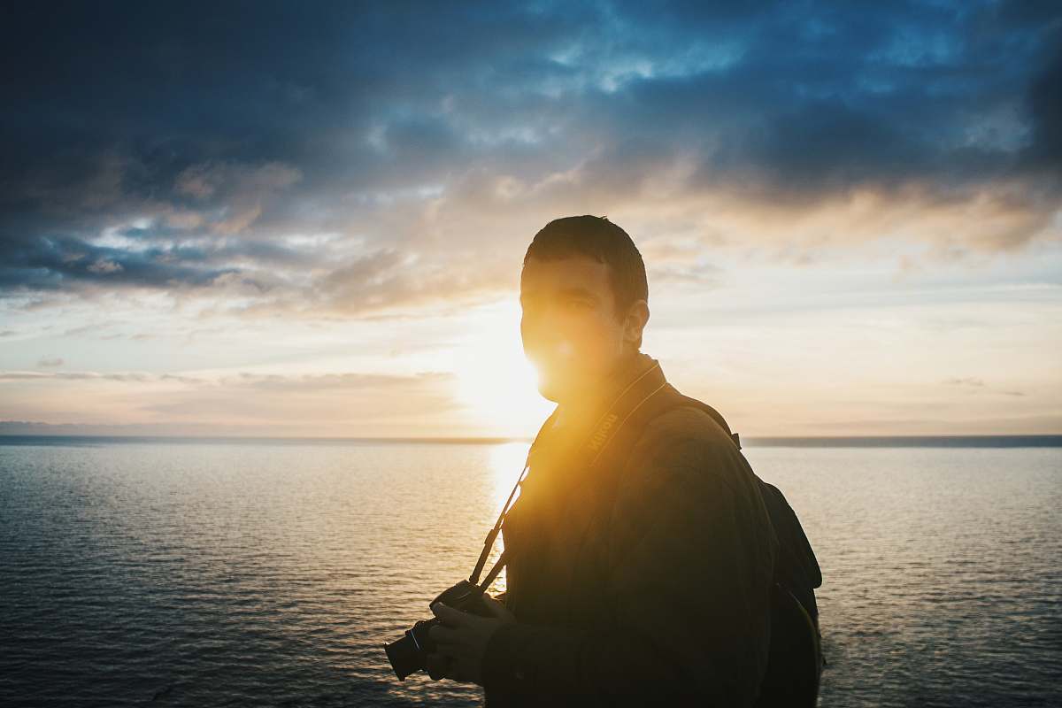 people man standing near body of water during daytime person