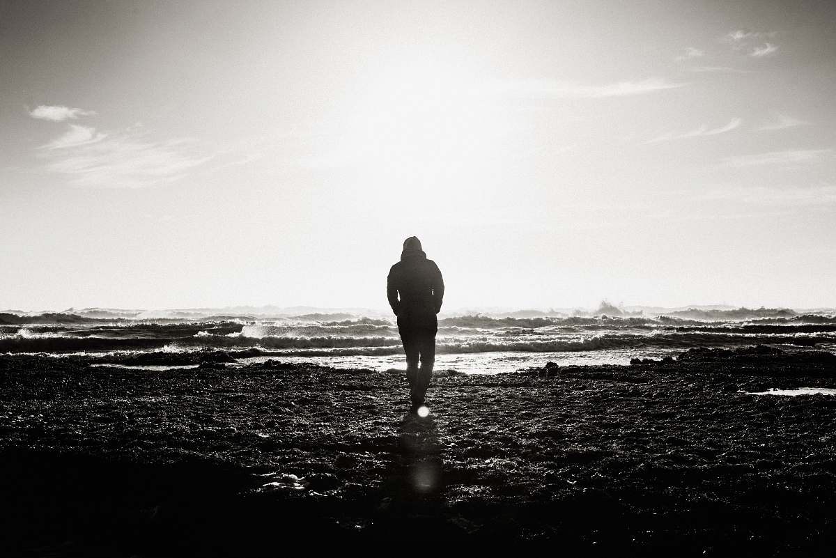 person man standing near ocean grayscale photography people