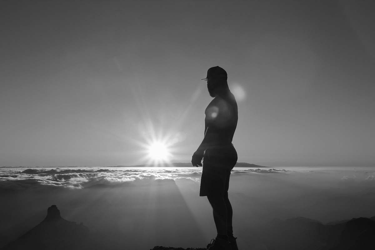 person man standing near the seashore black-and-white