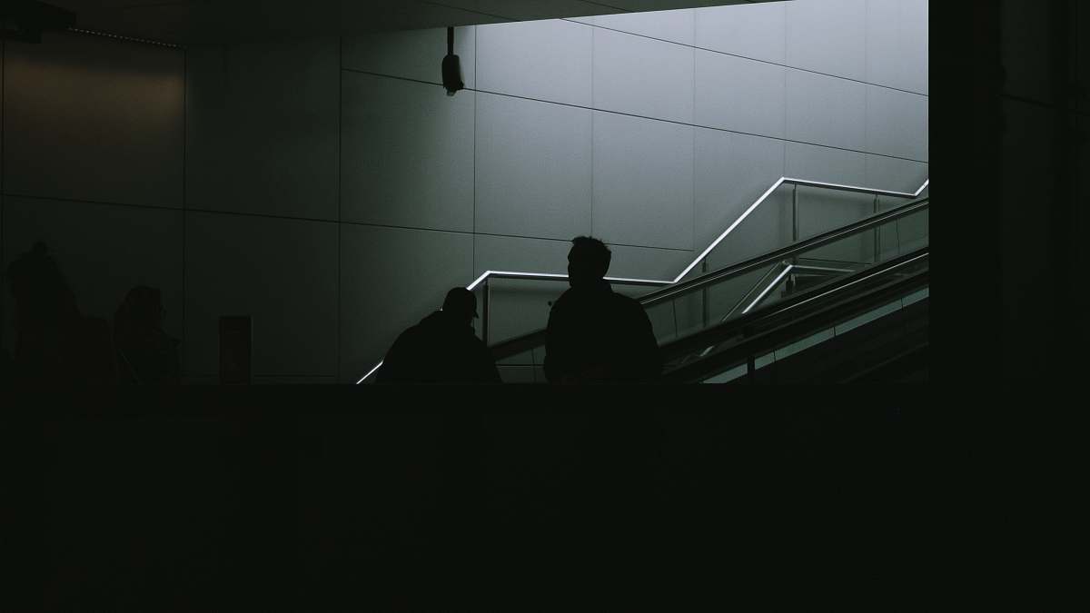 banister man standing on gray stair handrail
