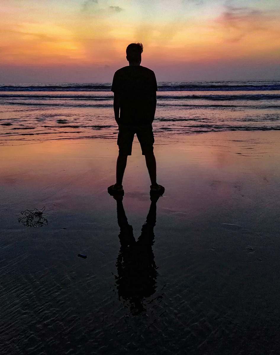 person man standing on shore at night standing