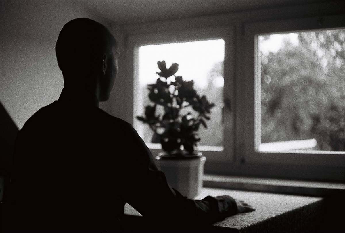silhouette person sitting in front of table with plant black-and-white