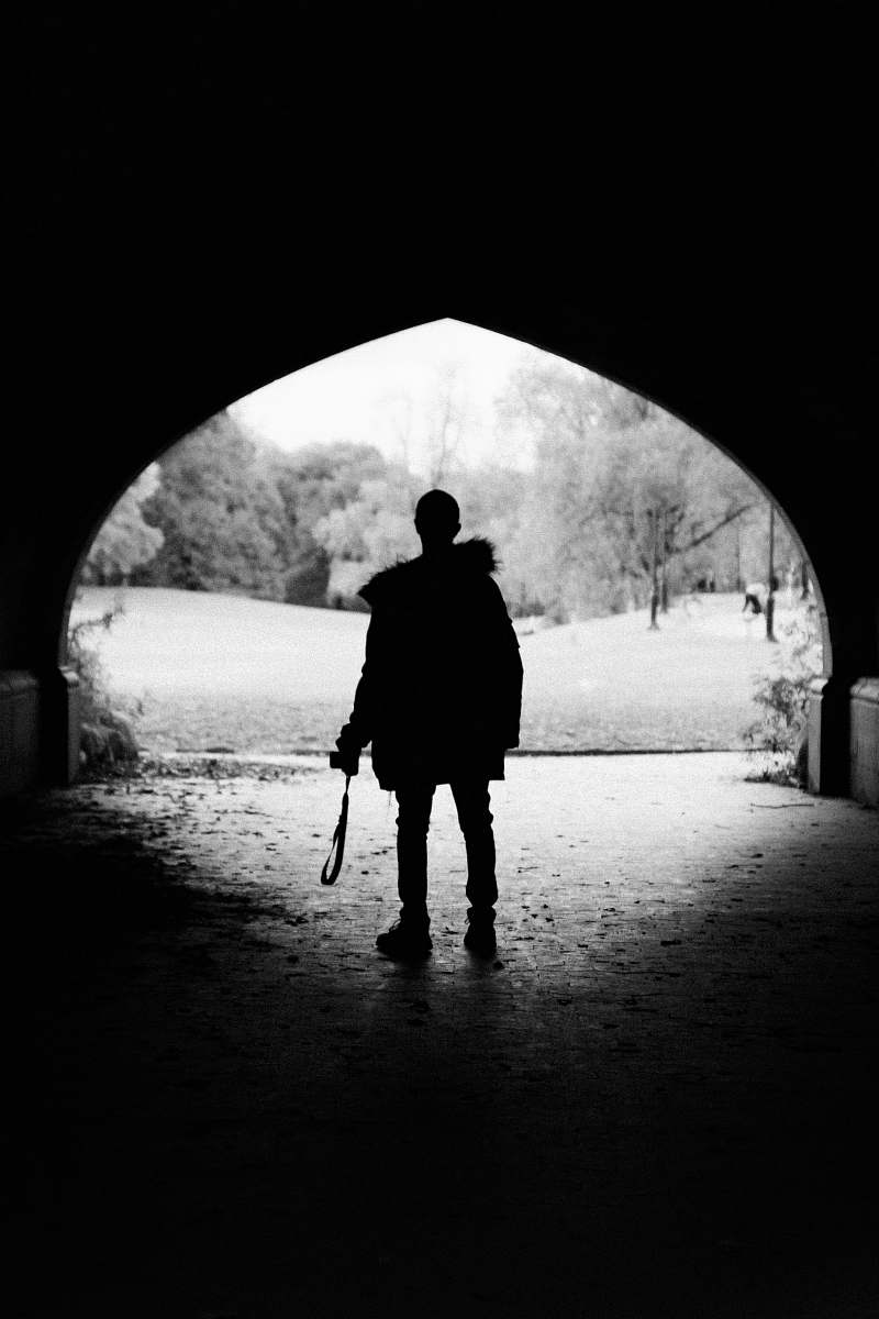 person person standing inside tunnel black-and-white