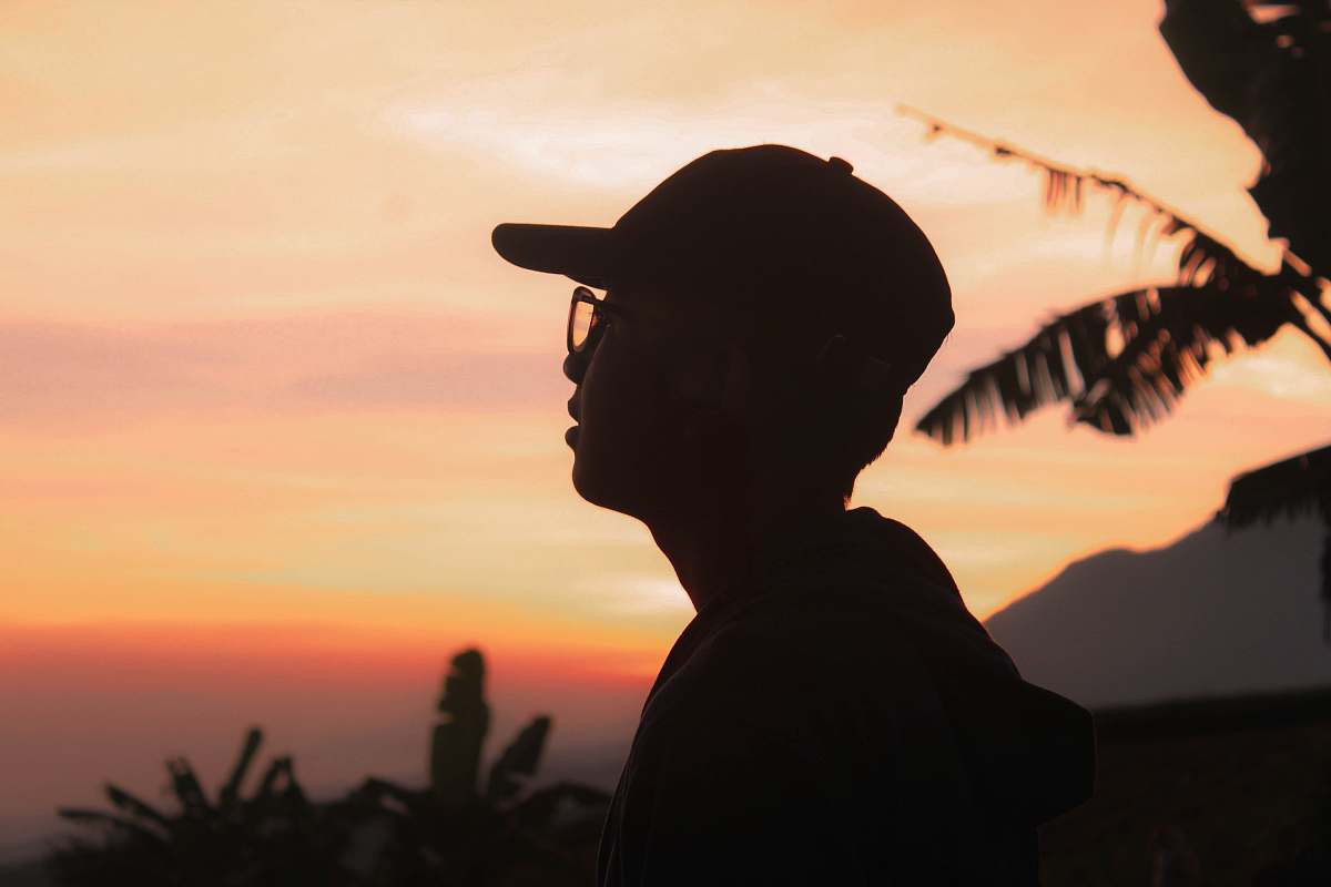 person person wearing a eyeglasses and hat during golden hour apparel