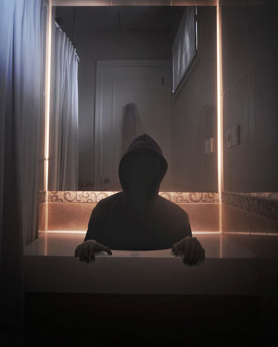 person person wearing hoodie inside room silhouette
