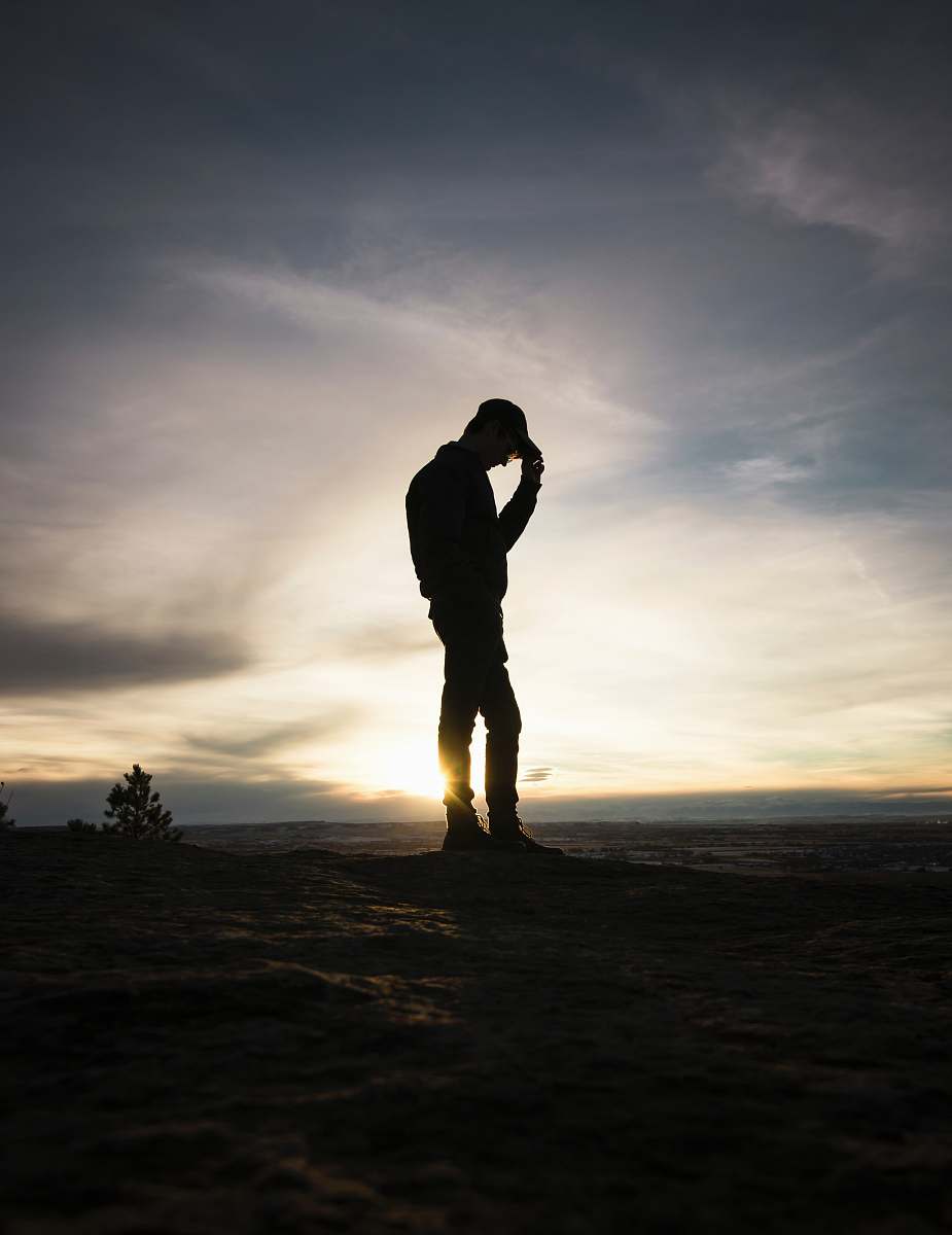 person silhouette man standing holding cap during sunset people