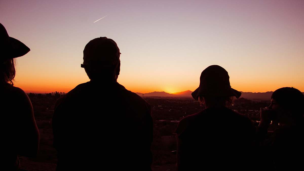 person silhouette of four standing people during golden hour people
