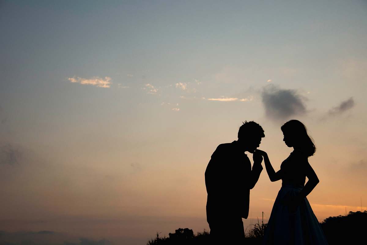 person silhouette of man kissing hand of woman people