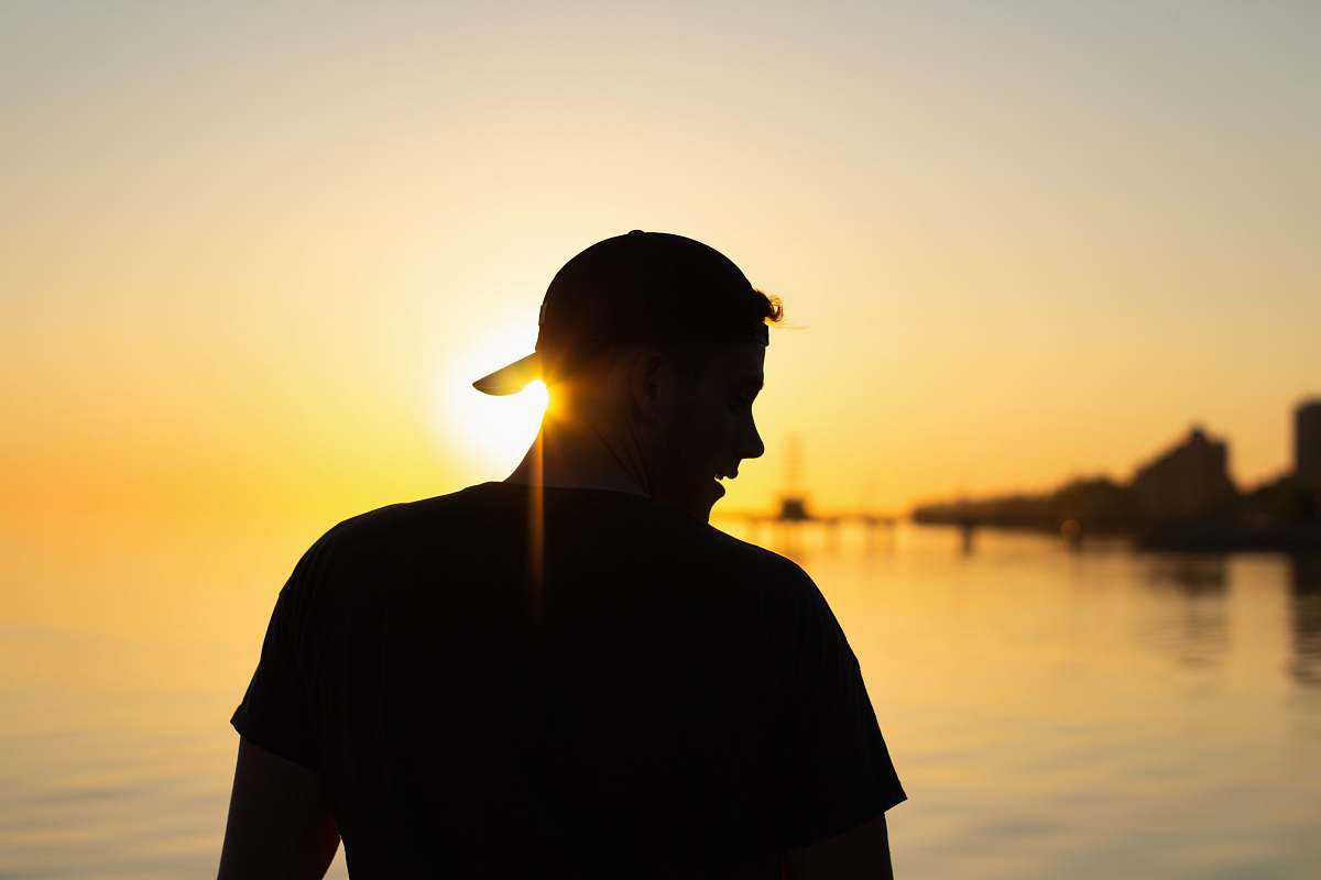 person silhouette of man wearing cap during sunset nature