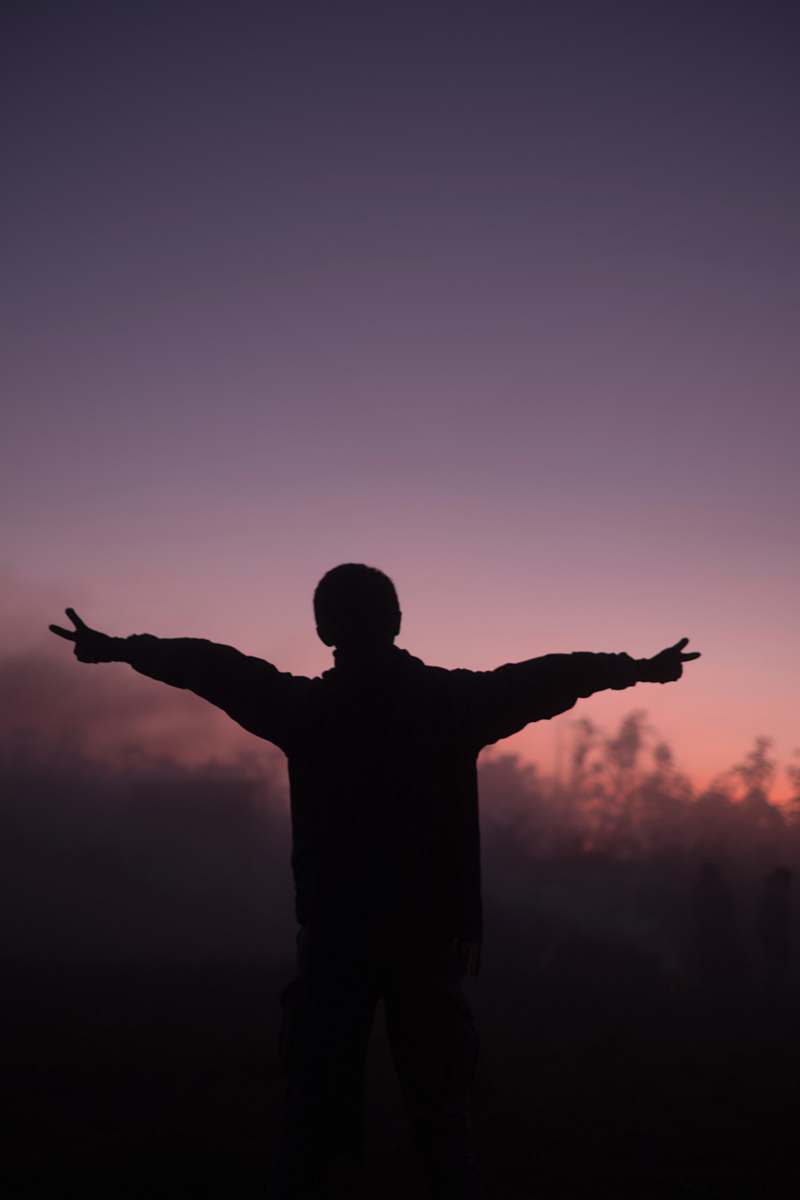 silhouette silhouette of person lifting arms worship