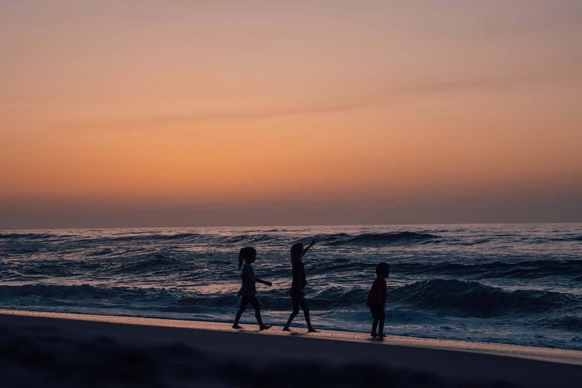 person silhouette of person on seashore during daytime silhouette