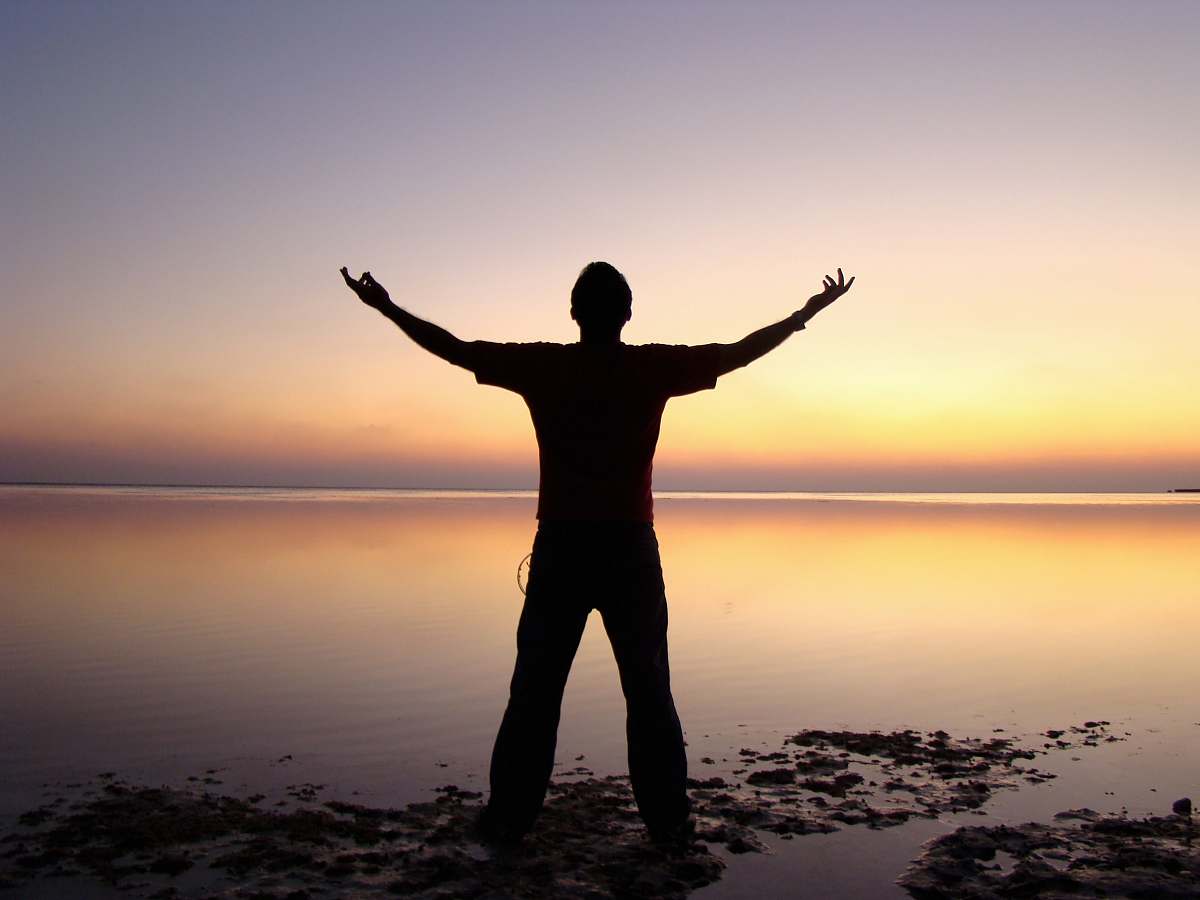 person silhouette of person standing beside body of water silhouette