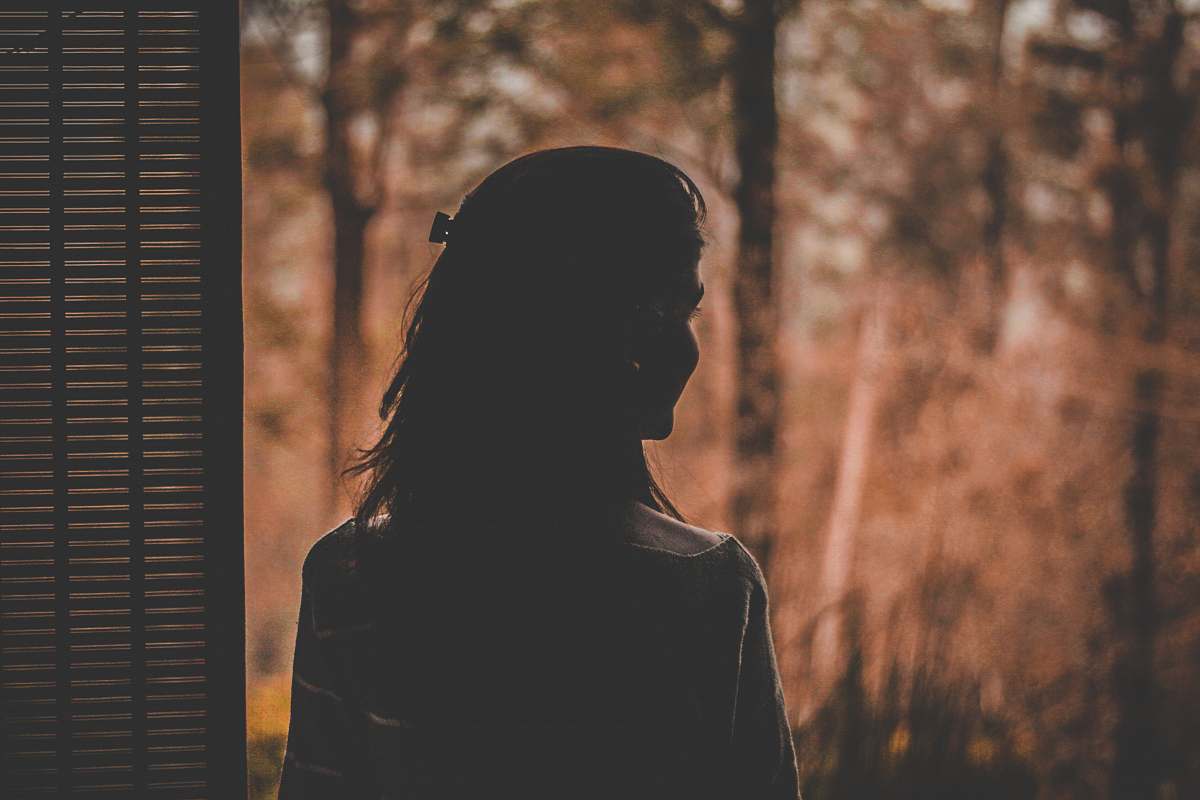 person silhouette of woman near window silhouette