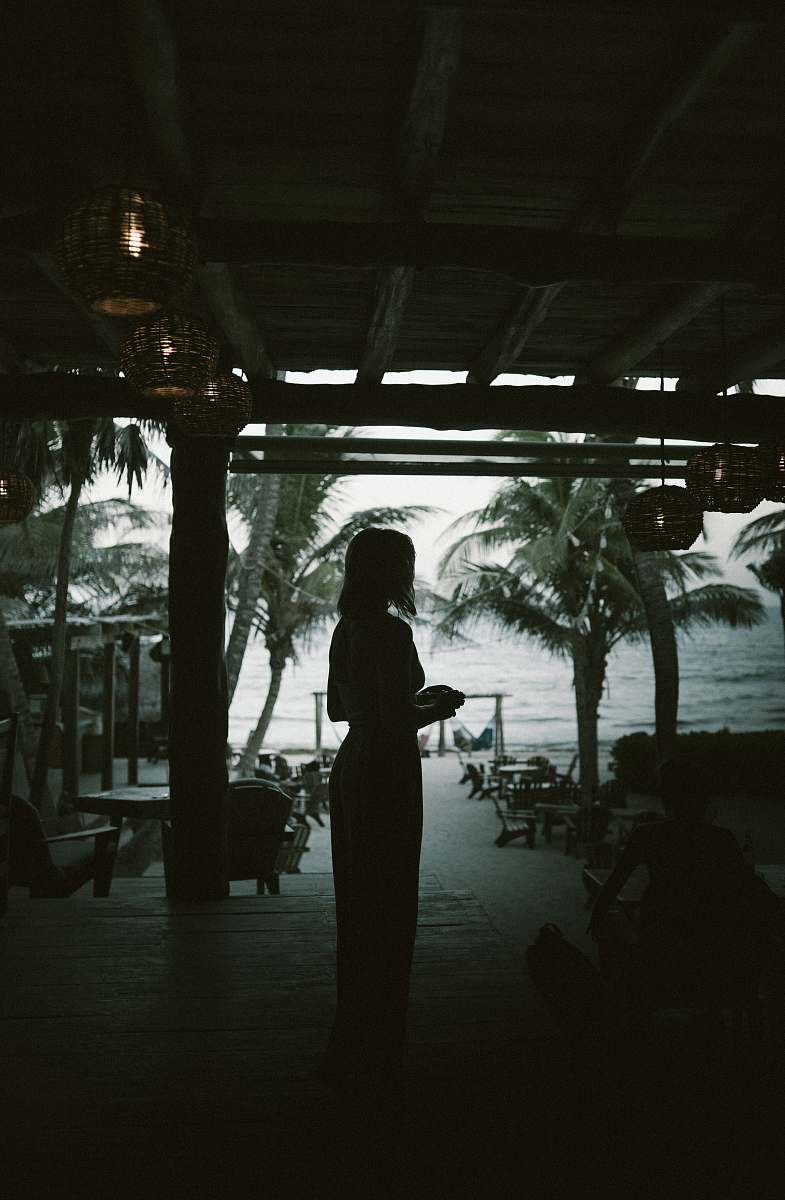 person silhouette of woman standing beside beach people