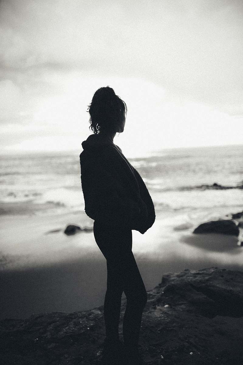 person silhouette of woman standing near sea standing